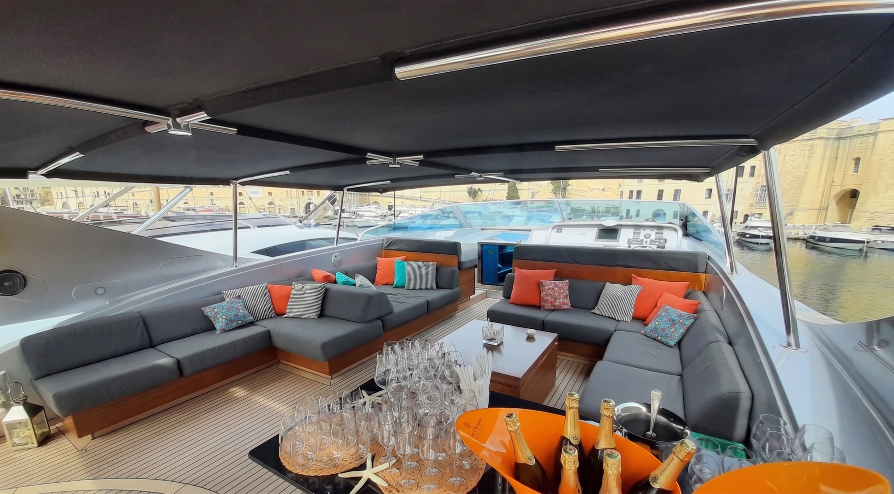 Shaded flybridge deck with lounge seating and champagne service